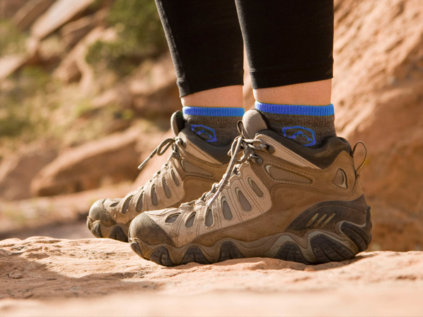 Hiker standing on rocky terrain wearing Cloudline socks