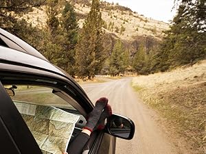 Person wearing Cloudline socks resting feet out window of car on dirt road