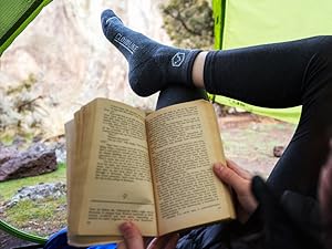 Person reading in tent wearing Cloudline socks