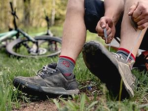 Mountain Biker wearing Cloudline socks trying shoes with bike in the background