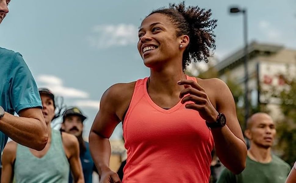 woman in salmon colored tank top running in group