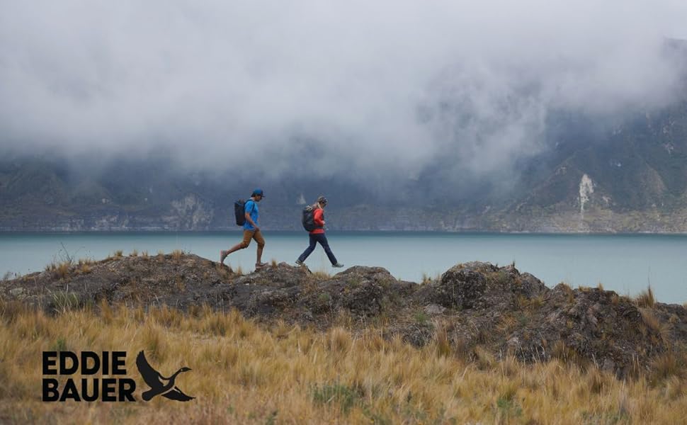 2 people hiking on ridge next to lake  with low clouds