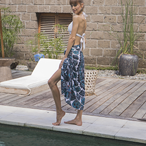 Woman wears blue and grey sugar skull sarong styled as skirt near pool